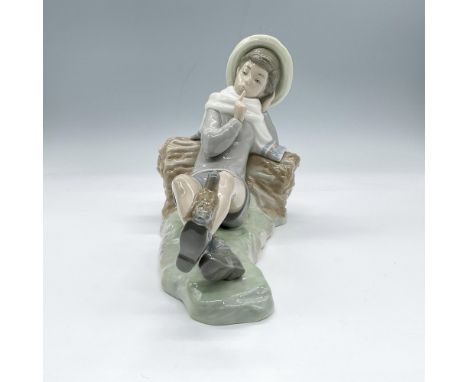 Glossy, hand made porcelain. Depicts a young boy, clothed in soft shades of blue and grey, wearing a wide-brimmed hat and a w