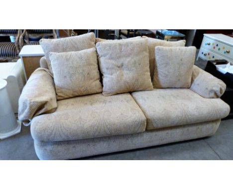 A modern sofa upholstered in beige fabric