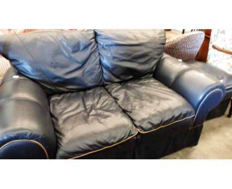 A leather upholstered sofa and matching footstool