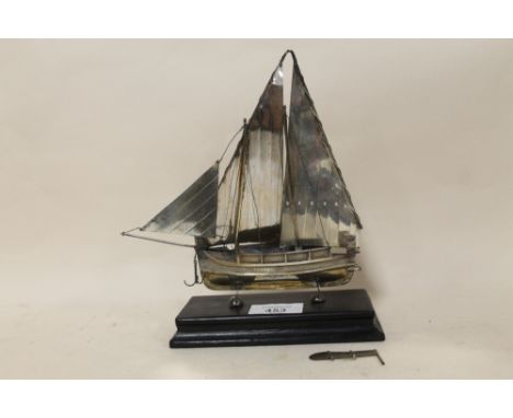 A CONTINENTAL STYLE STERLING SILVER MODEL OF A SAIL SHIP RAISED ON EBONISED PLINTH STAMPED 925 - DAMAGES TO SAIL 