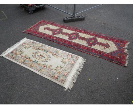 AN EARLY 20TH CENTURY WOOLLEN RUNNER, MAINLY RED GROUND  282 X 97 CM, TOGETHER WITH A CHINESE MODERN RUG (2)