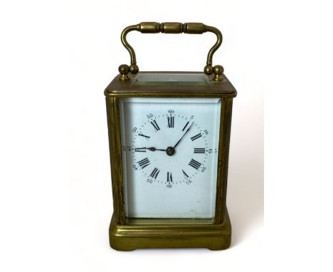 A gilt brass carriage timepiece
With enamel dial with Roman numerals, 14cm high.
