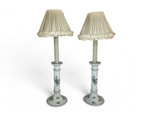 A pair of white porcelain blue floral decorated candlestick table lamps 
Together with a pair of pleated cream silk shades, f