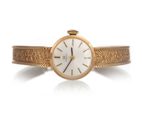 TISSOT NINE CARAT GOLD MANUAL WIND WRIST WATCH, the round dial with baton hour markers, 17mm case, on an integrated bracelet,