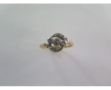 A diamond set ring - yellow shank and cross over shoulders each set with four 8-cut diamonds enclosing three old cut diamonds