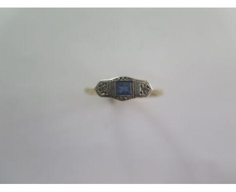 A sapphire and diamond ring - a centre square step cut sapphire flanked by two 8-cut diamond points in illusion plate - stamp