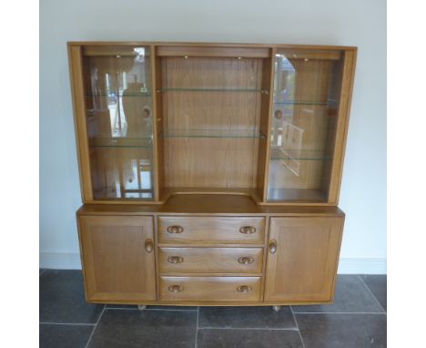 An Ercol Golden Dawn blonde elm sideboard with glazed two door top over two cupboards and three drawers - one with cutlery sl