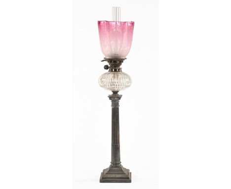 A Victorian silver plated Corinthian column oil lamp, with clear glass reservoir and cranberry shade.  Height excluding chimn