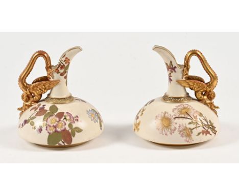 A pair of Royal Worcester blush ivory jugs, with gilt floral decoration and with winged mythical beast handles, circa 1888.  