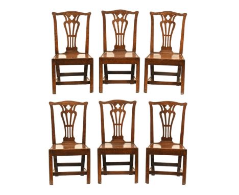 A good set of George III oak Chippendale style country dining chairs, with yoke shaped top rails with vase shaped pierced spl