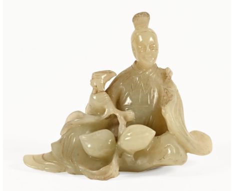 A small carved jade seated figure with lotus.  Height 8 cm.   CONDITION REPORT:  There is a chip to the upper section of the 