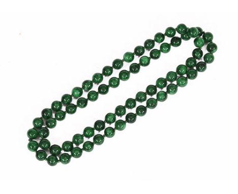A strap of jade or hardstone green beads.  Length 41 cm.