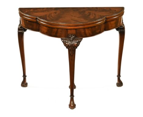 A well figured mahogany card table, of shaped outline and raised on carved cabriole legs terminating in scroll feet.  Width 9