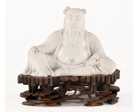 A Chinese white jade or hardstone Buddha, marked in pencil to the base Yogi, raised on a carved wooden stand.  Overall height