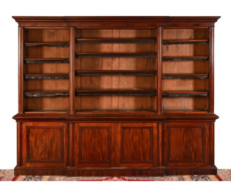 A Victorian mahogany open breakfront bookcase, of large form the top section with adjustable shelves, the base with four pane