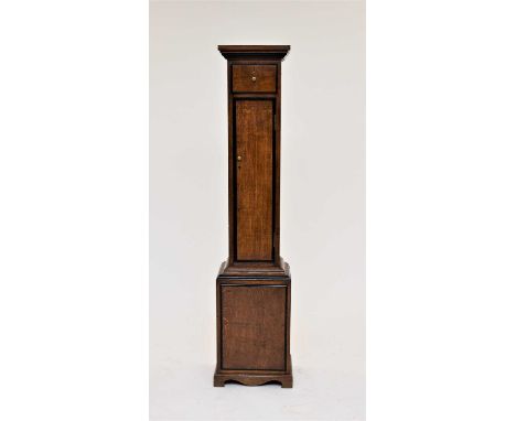 An Edwardian oak gun cabinet, of clock case form with ogee cornice above a small ammunition drawer and a long door with dark-