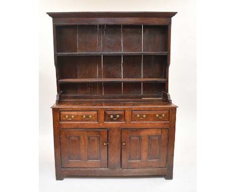 An 18th century oak dresser, Denbighshire, the characteristic two-tier hooded plate rack above a base with a two-plank top ov