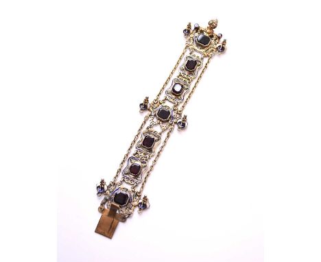 An Austro-Hungarian white metal garnet and enamel bracelet, the push clasp with figural thumbpiece, not stamped (some damage)