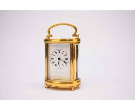 A French gilt brass carriage timepiece, early 20th century, five-glass oval form with swing carrying handle, the white enamel