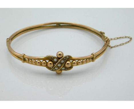 A yellow metal bangle set with pearl, tests electronically as 9ct gold, internal width at widest, 60mm, 10.8g