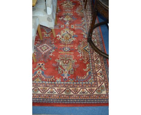 A PATTERNED GROUND CARPET, on red ground, approximate size 200cm x 300cm, Delphi label attached