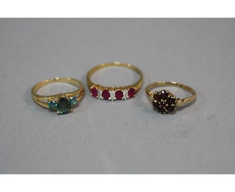 THREE LATE 20TH CENTURY 9CT GOLD DRESS RINGS, to include a green sapphire three stone, a ruby and diamond half eternity and g