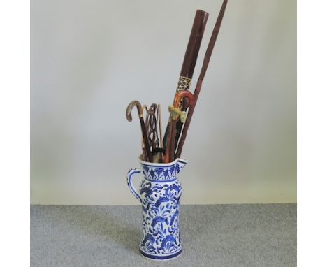 A pottery stick stand, 54cm tall, containing various walking sticks