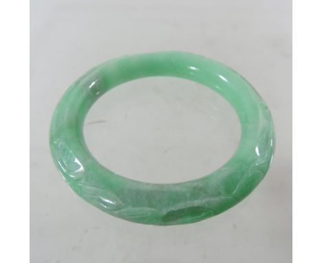 A jade coloured hardstone bangle, together with a carved nut bangle