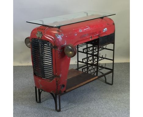 A contemporary glass topped bar, constructed from the front end of a Massey Ferguson tractor, fitted with a wine rack and und