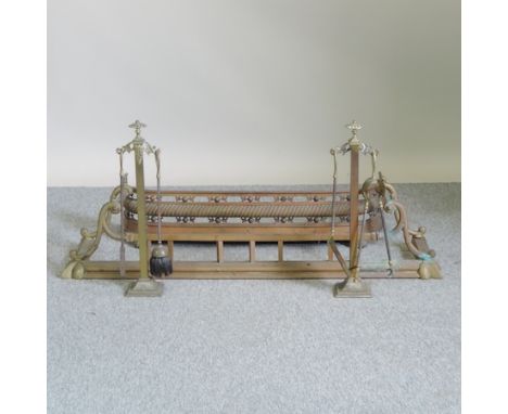 A 19th century brass fender, 128cm wide, together with another smaller and a set of fire tools