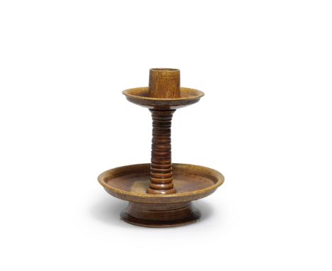 AN AMBER-GLAZED CANDLESTICKTang DynastyThe vessel fitted with a cylindrical candle holder centring a circular drip pan raised