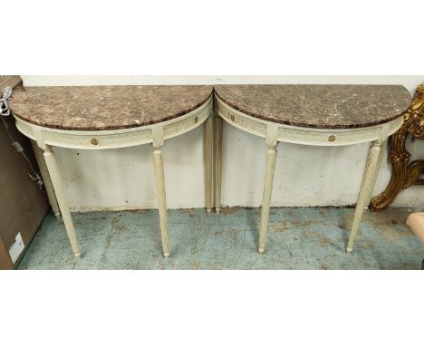 DEMI LUNE CONSOLE TABLES, a pair, painted bases with gilt highlights and brown marble tops, 83cm H x 100cm W x 50cm D. (2) 