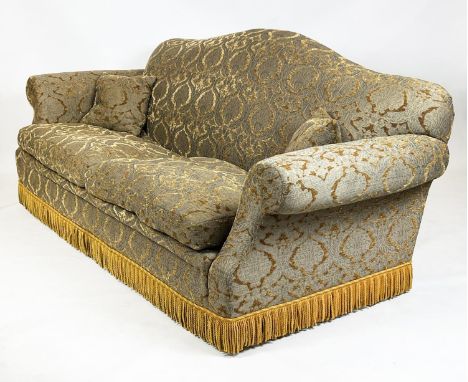 SOFA, Victorian design with camel back and scroll arms, upholstered in gold cut velvet and bullion fringe, 215cm W x 85cm D x