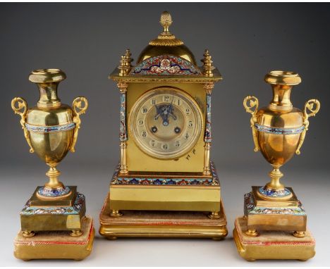 A late 19th century French brass, gilt metal and champleve clock garniture, the clock with pineapple finial to the dome surro