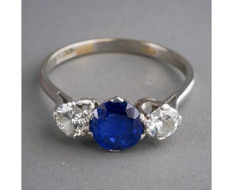 A sapphire and diamond three-stone ring, set with a mixed-cut sapphire flanked by two round brilliant-cut diamonds approx 0.2