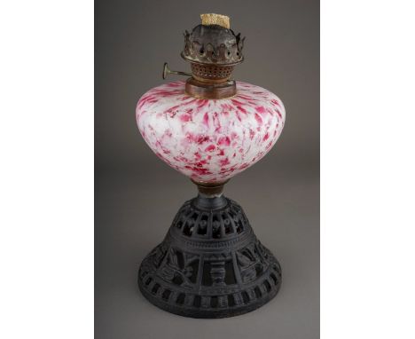 A late Victorian oil lamp base, the burner by Wright and Butler, the reservoir of speckled pink, white and silver glass, on a