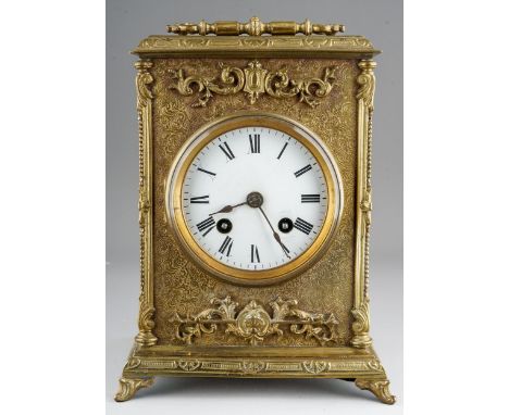 A late 19th century brass and gilt metal cased mantel clock of rectangular form, ornate swing handle to the top, the case, th