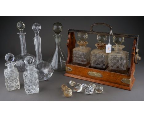 An Edwardian oak three bottle tantalus with silver plated mounts, initialled plaque to front, width 35.5cm, together with thr