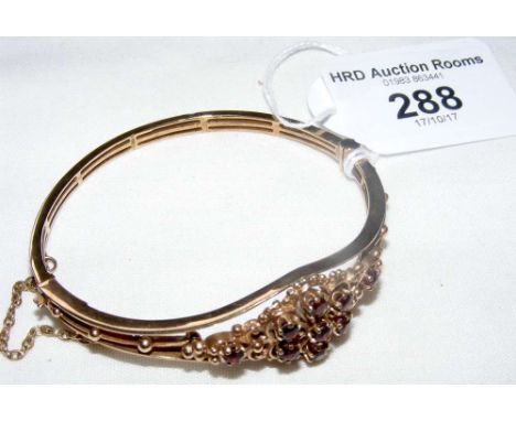 A 9ct gold decorative garnet bangle in presentation box
