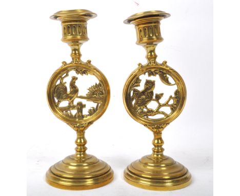 A pair of Victorian 19th century brass day &amp; night candlestick holders. The lot comprising of a candlestick with with owl