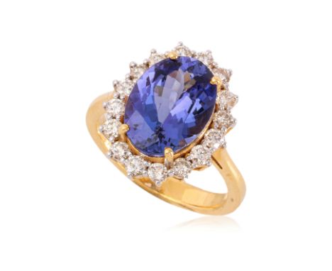 A TANZANITE AND DIAMOND 'HALO' RING
Featuring an oval tanzanite weighing approximately 5.05 Cts, mounted in a yellow gold set