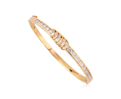 A HIGH KARAT GOLD DIAMOND HINGED BANGLE
Featuring round brilliant cut and tapered baguette cut diamonds totalling approximate