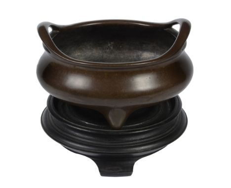  A Chinese bronze tripod censer, 18th/19th century  , of compressed form with outswept pierced handles, Xuande six- character