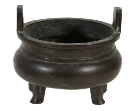  A Chinese silver-inlaid bronze tripod two- handled censer,     ding  , decorated to the body with a band of scrolling foliag