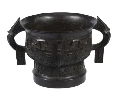  A Chinese bronze Western Zhou style ritual food vessel,  gui  , the body moulded with stylised dragons, either side of a cen