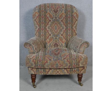 A 19th century style armchair in tapestry upholstery on turned tapering supports. H.100 W.83 D.70cm 