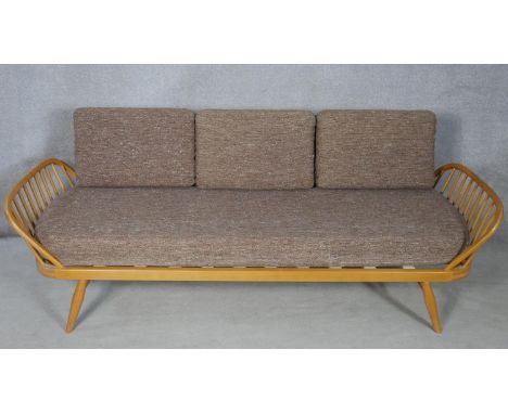 A mid century blonde elm and beech Ercol model 355 studio couch with surfboard back and original upholstery with maker's labe
