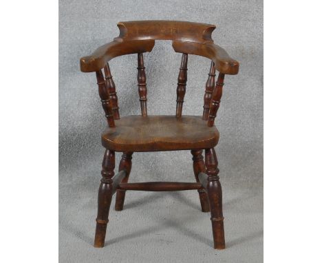 A 19th century elm child's stick back armchair with moulded seat above turned stretchered supports. H.56cm 