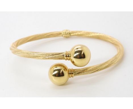 A bright yellow metal ball ended bangle, (rubbed Italian hallmarks) weight 9.6gms Condition Report:Available upon request