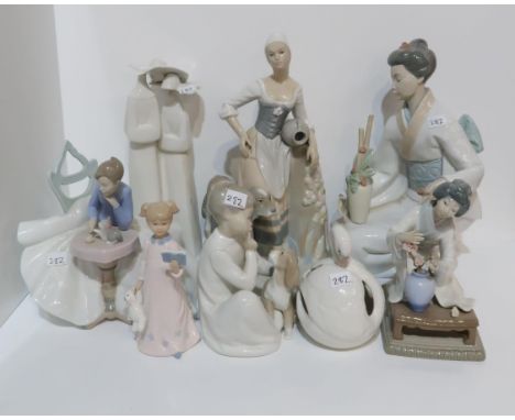 A collection of Lladro, Nao and other Spanish figures including a girl sat at a table with a kitten Condition Report:Availabl